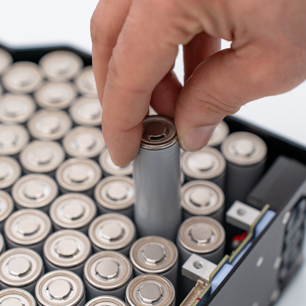 Close-up of a single cell being removed from a MAKI pack next to its smart battery management electronics